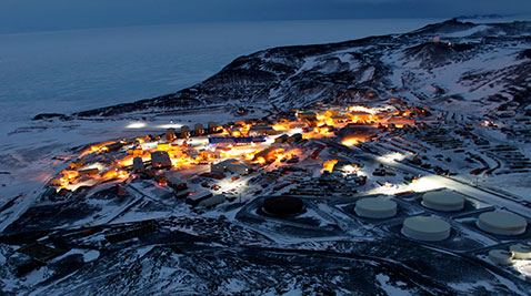 The skyline of McMurdo base at night, lit up it seems like a real town.
